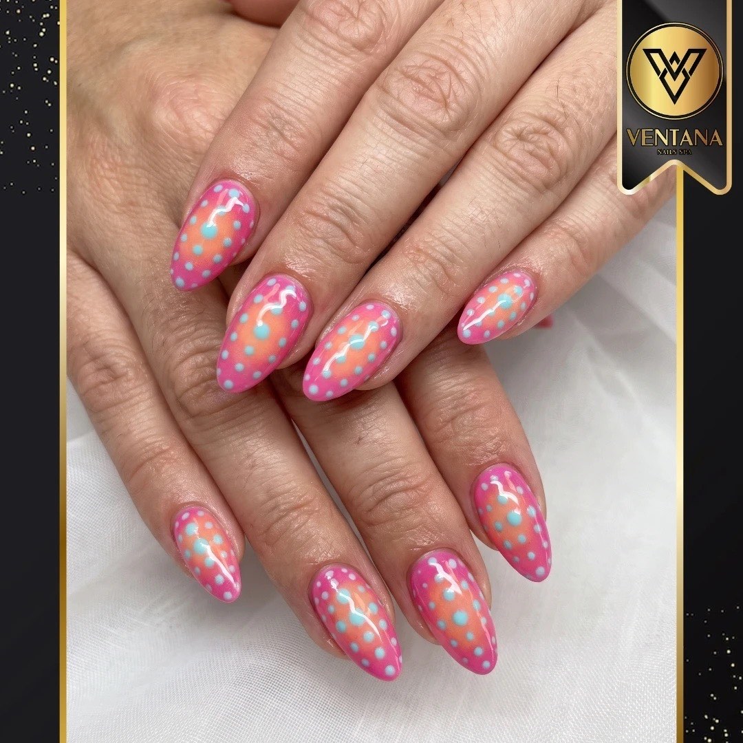 Almond nails in bright pink with white, orange and blue polka dots