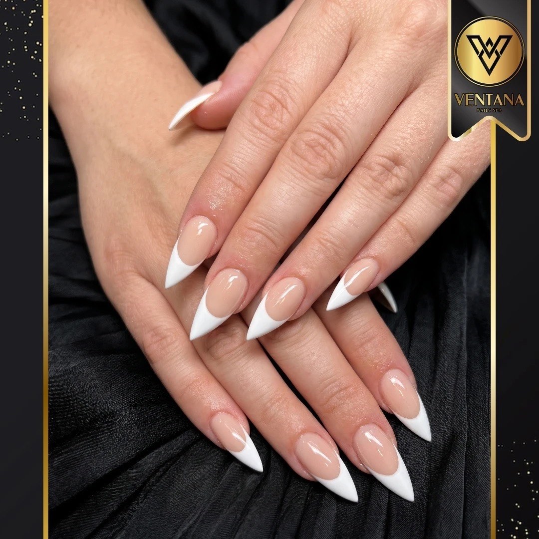 Classic white French tip nails in a long stiletto shape